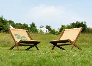 Wecandoo avec artisan, planches de bois brut, outils de menuisier et mains en train d’assembler un meuble, posé sur un établi lumineux, ambiance artisanale et conviviale, mettant en valeur l’apprentissage et la fierté de créer ses propres meubles.