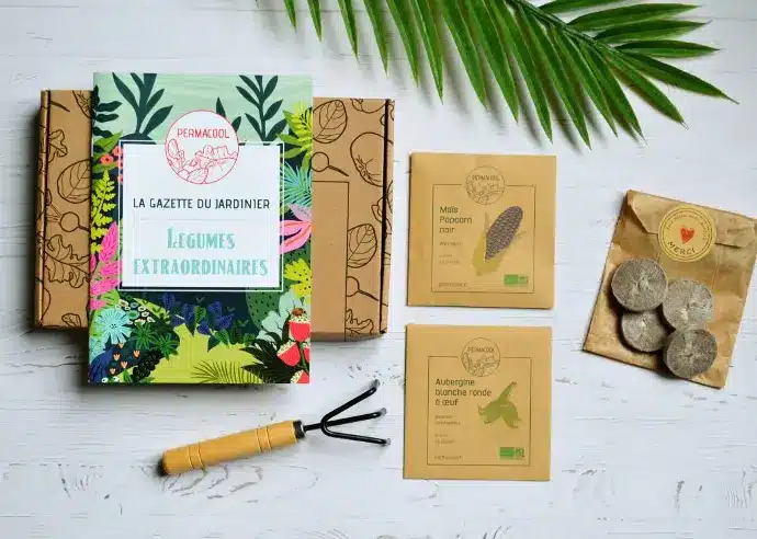 Idée cadeau anniversaire DIY pour sa femme, sa sœur ou une amie créative : coffret Les Raffineurs pour fabriquer des bougies en cire végétale, pots en fer et huiles essentielles, posé sur une table avec fleurs séchées, ambiance douce et artisanale rappelant les soirées d’été en extérieur.