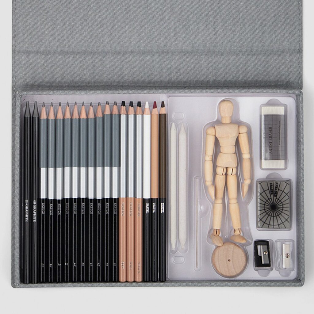 Idée cadeau anniversaire DIY pour sa femme, sa sœur ou son amie créative : coffret de croquis Emerging Artist Les Raffineurs comprenant carnet à dessin, crayons et accessoires, posé sur une table en bois avec un croquis en cours, ambiance artistique et inspirante, lumière naturelle douce mettant en valeur la création manuelle et l’expression personnelle.