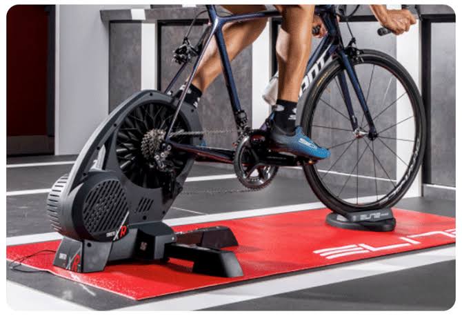 Ce home trainer mesure la puissance de pédalage en direct et ajuste la résistance selon le parcours simulé, ce qui change complètement la sensation par rapport à un rouleau classique.