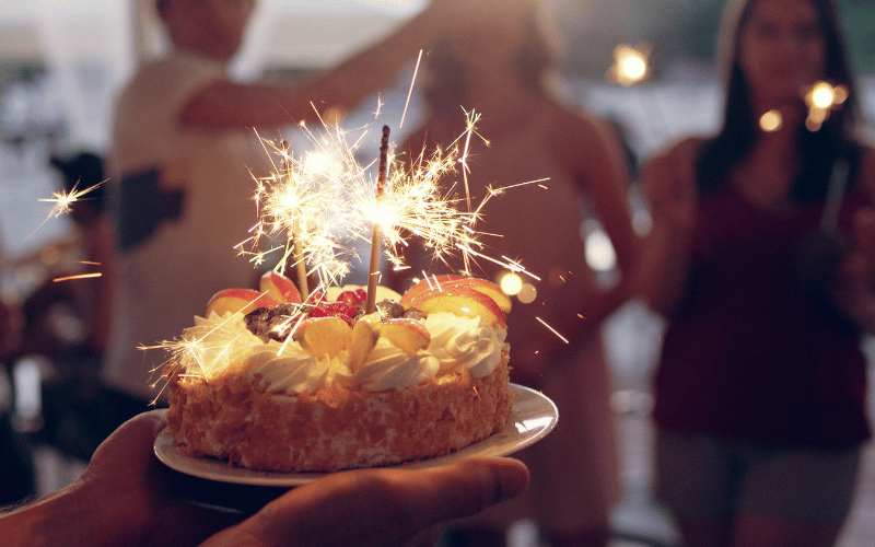 gateau d'anniversaire avec des bougies et des personnes heureuses