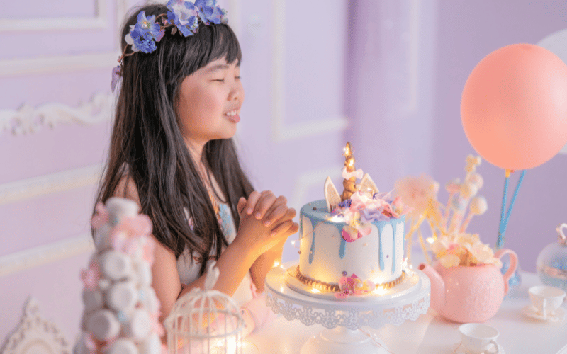 une petite fille qui souffle ses bougies d'anniversaire