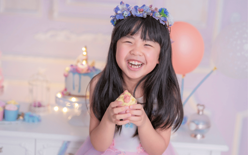 une fille qui est heureuse en mangeant son gateau d'anniversaire