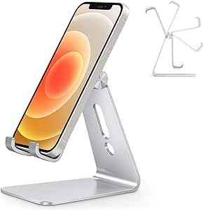 Un support design en bois ou en métal maintenant un smartphone en position inclinée sur un bureau, à côté d’un ordinateur portable et de cahiers, pratique pour suivre un cours, faire une visio ou binge-watcher une série confortablement.