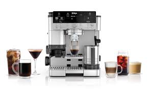 Image de la machine à café Ninja Luxe Café Premier Series, une cafetière 3-en-1 permettant de préparer des expressos, du café filtre et du cold brew. Équipée de la technologie Barista Assist, elle offre des recommandations de mouture et un dosage précis pour des boissons de qualité professionnelle à la maison. Son design élégant en acier inoxydable s'intègre parfaitement dans une cuisine moderne.