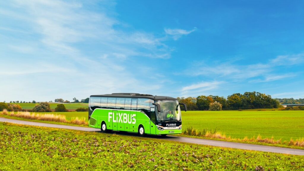 Bus FlixBus vert stationné à quai dans une gare routière française, illustration d’un article journalistique sur l’évolution de FlixBus en 2025 et ses promesses de mobilité accessible