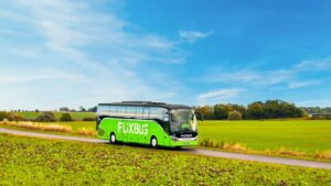 Bus FlixBus vert stationné à quai dans une gare routière française, illustration d’un article journalistique sur l’évolution de FlixBus en 2025 et ses promesses de mobilité accessible