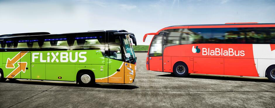 Deux bus longue distance stationnés, l’un aux couleurs vertes de FlixBus et l’autre rouges de BlaBlaCar Bus, illustrant le choix entre les deux compagnies de transport low-cost