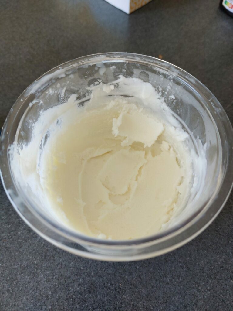 Photo d’une glace maison à la fraise préparée avec un Ninja Creami, servie dans une coupe en verre avec quelques morceaux de fraise fraîche en topping, texture onctueuse et naturelle, sans colorant ni additif, idéale pour l’été, recette légère et facile à faire avec des ingrédients simples, illustrant parfaitement la glace fraise-yaourt de l’article