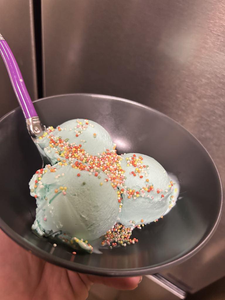 Glace maison bleue à base de bonbons Schtroumpfs fondus, présentée dans un bac Ninja Creami avant mixage, recette originale et colorée inspirée des bonbons Haribo, idéale pour les enfants ou pour une glace ludique, texture onctueuse obtenue après passage au Ninja Creami, préparation facile avec lait, crème et colorant alimentaire