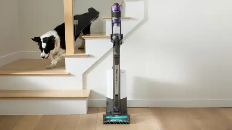 Photo de l’aspirateur sans fil Shark Power Detect Clean & Empty modèle IP3251EUT avec sa base de recharge, un appareil moderne et puissant conçu pour l’entretien de la maison, idéal pour les sols mixtes et les foyers avec animaux, aspirateur balai sans sac Shark performant et hygiénique