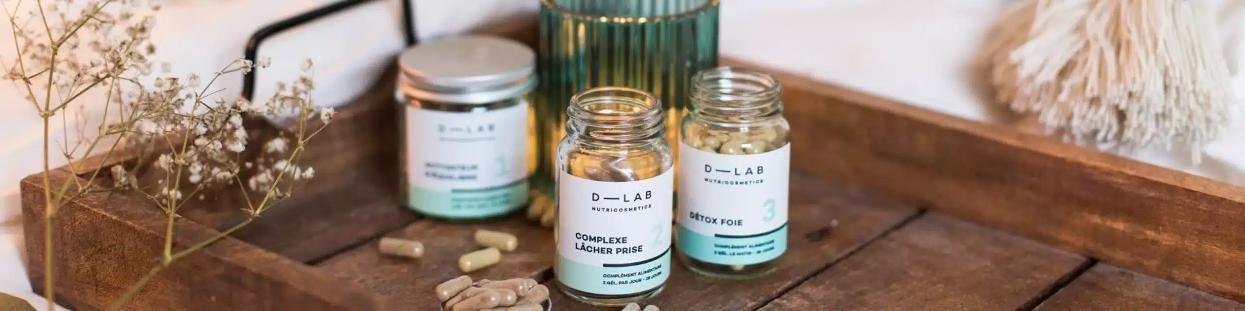 Photo de plusieurs compléments D LAB Nutricosmetics posés sur une surface claire, flacons en verre au design minimaliste illustrant mon avis détaillé et mes tests sur les cures collagène, cheveux et minceur