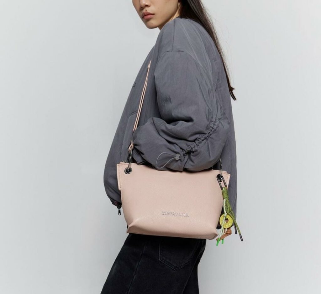 Sac Bimba Y Lola modèle Chihuahua porté à l’épaule par une femme en tenue urbaine colorée, avec un style audacieux et graphique, idéal pour apporter une touche originale à une tenue simple, illustrant l’univers créatif de la marque espagnole.