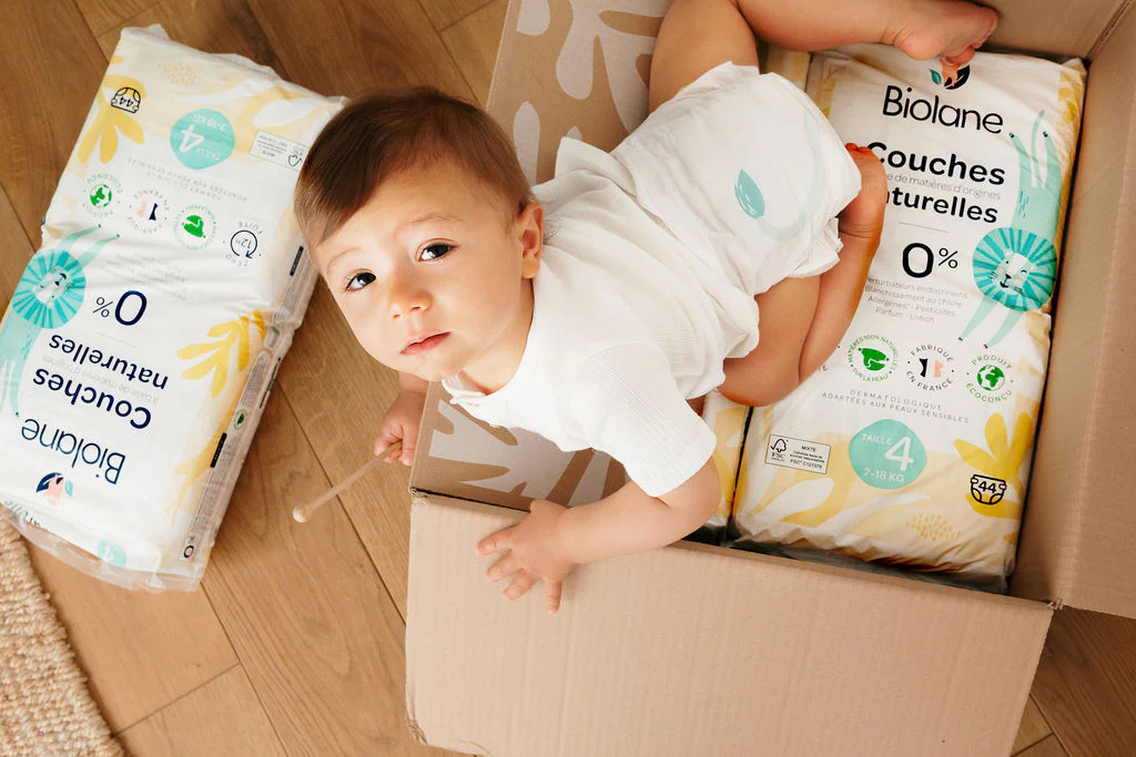 Photo d’un carton d’abonnement couches Biolane contenant plusieurs paquets, illustrant les formules souples, le rapport qualité-prix, les livraisons régulières et la comparaison avec d’autres marques de couches bébé.
