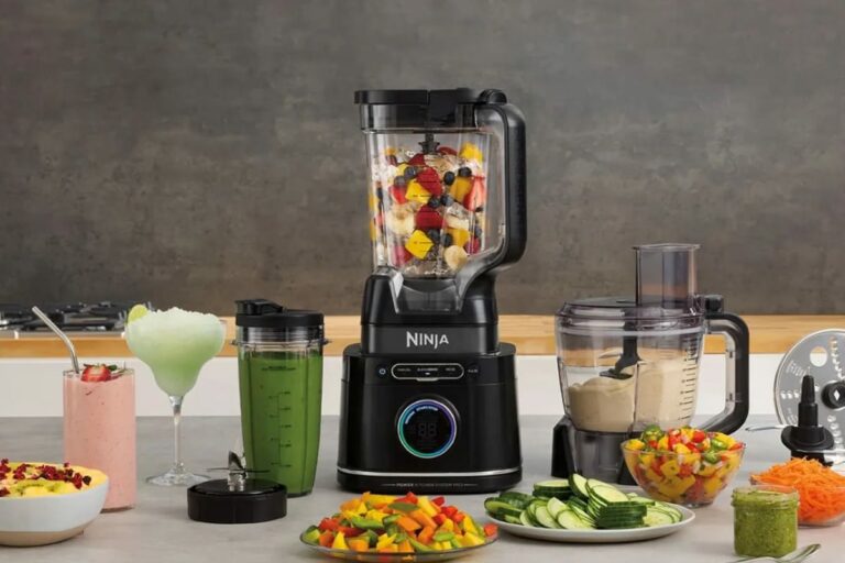 photo du blender ninja detect tb301eu posé sur un plan de travail avec le grand bol transparent et le gobelet individuel, écran blendsense allumé et ingrédients autour, image réaliste pour illustrer un test complet d’un blender intelligent performant