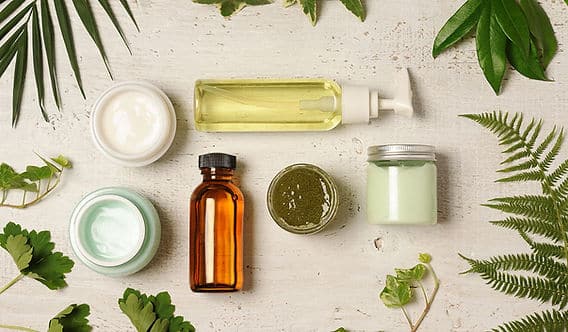 visuel d’un flacon de cosmétique au design minimaliste posé sur un fond naturel avec feuilles vertes, illustrant l’idée de choisir une marque écologique, respectueuse de l’environnement et de la santé