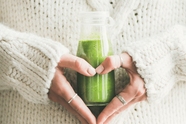 Photo d’un verre de jus vert détox à base de légumes et d’herbes, posé à côté d’un flacon de compléments alimentaires, représentant les cures naturelles pour soutenir le foie et la détoxification