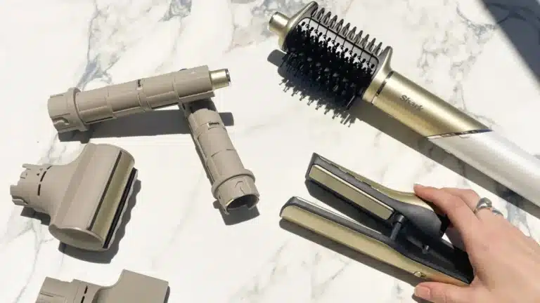 Photo du sèche-cheveux multifonction Shark Glam posé sur une coiffeuse, illustrant le test et avis sur son design doré et ses usages coiffants variés.
