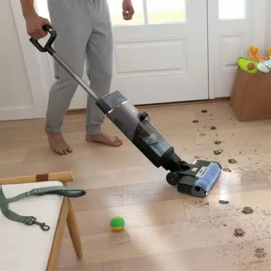 Aspirateur laveur sans fil Shark HydroVac WD210EU nettoyant un parquet clair, avec réservoir double et tête pivotante visibles.