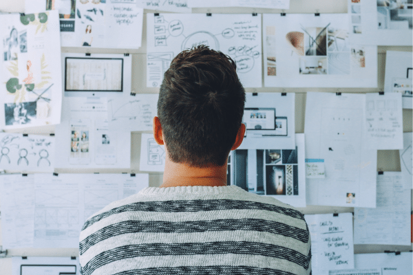 Vue d’un bureau lumineux avec un ordinateur portable ouvert, un carnet de notes, une tasse de café et une plante, illustrant le quotidien d’une auto-entrepreneuse bien organisée