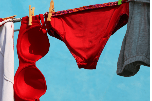 Culotte menstruelle en dentelle délicate dans un filet de lavage blanc, illustrant les astuces pour prolonger la durée de vie comme l’utilisation d’un savon doux ou le contrôle des coutures.