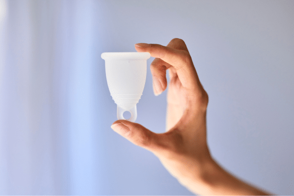 Coupe menstruelle en silicone médical posée sur une étagère de salle de bain, protection réutilisable qui offre une autonomie longue pour flux moyen à abondant.