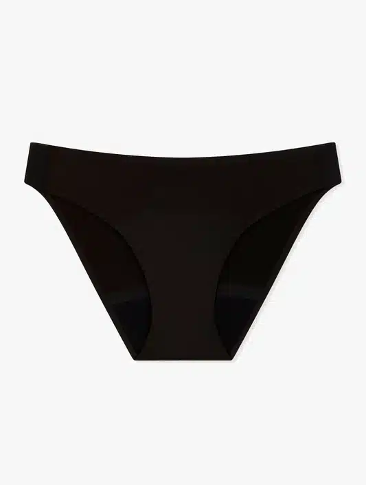 Rinçage d’une culotte menstruelle Smoon à l’eau froide au-dessus d’un lavabo, illustrant la routine d’entretien.