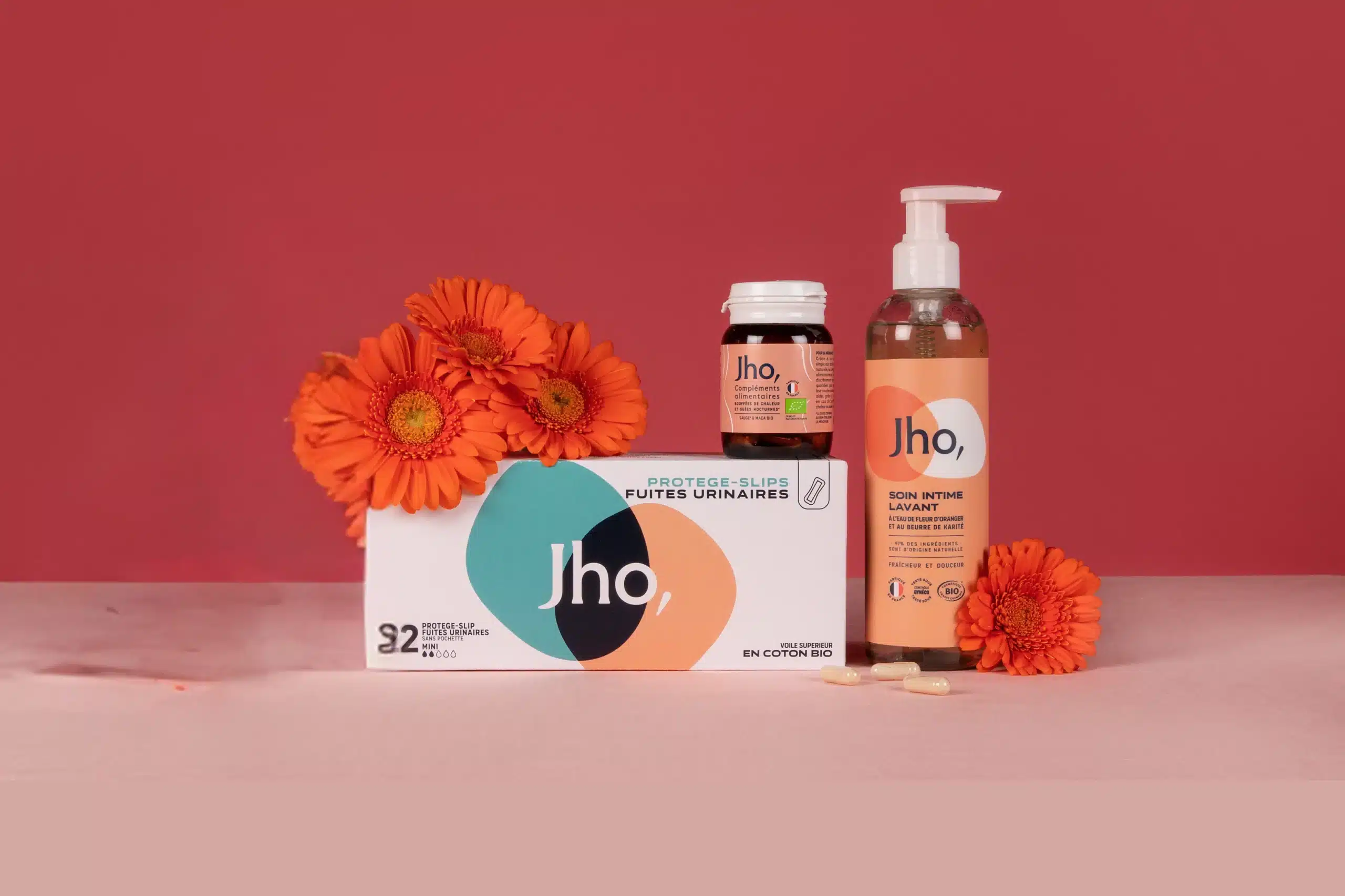 Produits Jho posés sur une table en bois clair, incluant tampons en coton bio, culottes menstruelles et gel lavant intime, illustrant un test et avis complet de la marque.