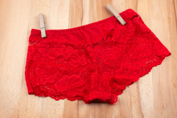 Gros plan de plusieurs culottes menstruelles en coton bio posées sur un panier à linge, illustrant un guide pratique sur l’entretien et le lavage pour préserver absorption et durée de vie.