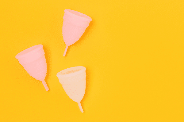 Photo de deux cups menstruelles posées sur une serviette en coton clair, illustration de mon comparatif des meilleures marques Jho et So’Cup, testées pour le confort, la souplesse et la facilité d’entretien, avec conseils pratiques pour bien la choisir.