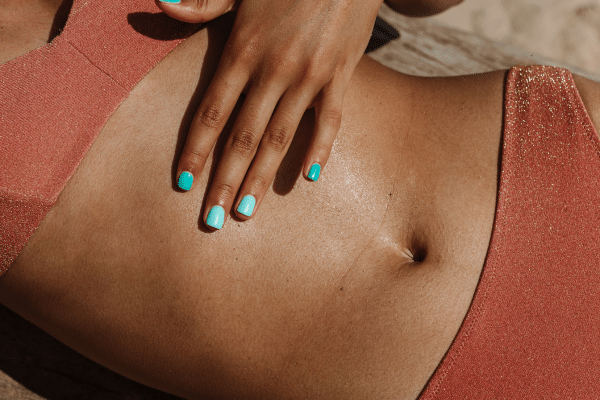 Photo de plusieurs maillots de bain menstruels étendus au soleil sur une serviette de plage, illustration de mon comparatif complet des meilleures marques comme Smoon, So’Cup, Mademoiselle Culotte et Eve and Co, testés pour le confort, la fiabilité et le style.