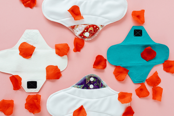 Photo de plusieurs serviettes hygiéniques lavables en coton bio posées sur une surface claire, exemple de protections menstruelles réutilisables confortables et écologiques pour flux léger à abondant, utilisées dans mon comparatif personnel.