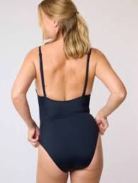 Femme à la plage portant un maillot menstruel Smoon noir, illustrant son efficacité pour flux léger à moyen.