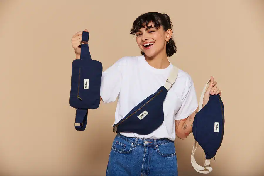 Sac Hindbag en coton biologique épais posé sur une table avec des couleurs naturelles, ambiance chaleureuse, vision d’ensemble de la marque engagée, premier contact avant un test complet, découverte d’une marque responsable et joyeuse, visuel lié au test et avis Hindbag pour aider le lecteur à choisir entre les différents modèles.