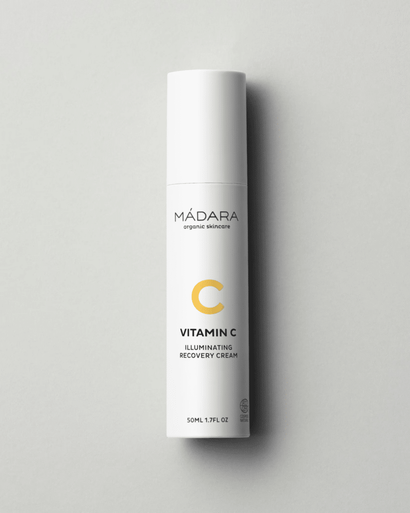 Crème Vitamin C Illuminating Recovery Cream de MÁDARA en pot en verre, texture onctueuse appliquée sur peau nue pour raviver l’éclat d’un teint terne et sensible