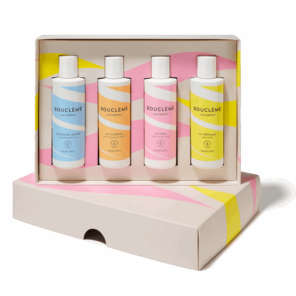 Produits Bouclème pour cheveux bouclés, frisés et ondulés posés sur un plan de salle de bain, illustrant une marque clean et hydratante.