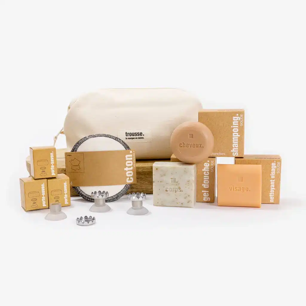 Les produits d’hygiène La Marque En Moins testés, gel douche solide, shampoing solide, dentifrice et lavant mains, disposés sur un plan de salle de bain minimaliste.