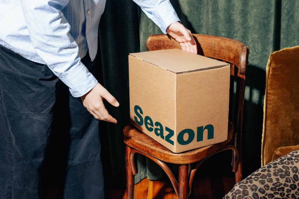 Photo d’un colis Seazon livré à domicile, contenant des plats prêts à déguster emballés individuellement avec leur étiquette et Nutri-Score visible. L’image évoque la première expérience utilisateur et la fraîcheur des repas reçus.