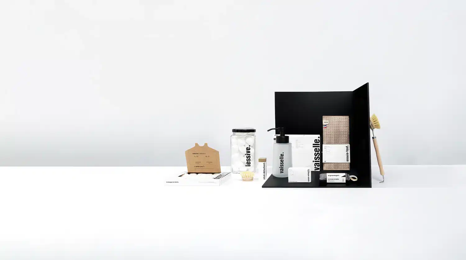 Produits d’hygiène La Marque En Moins posés sur une étagère de salle de bain, shampoing solide, gel douche, dentifrice et savon liquide rechargeables, illustrant un article test et avis.