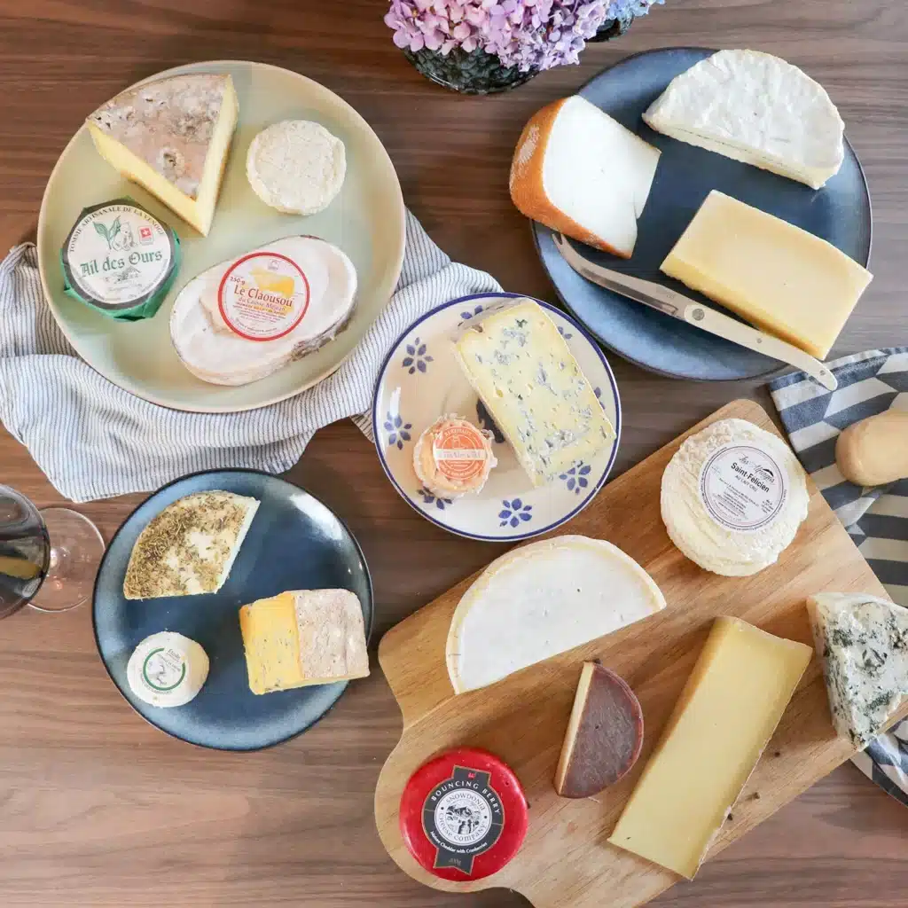 Image montrant le contenu d’un abonnement mensuel La Box Fromage avec quatre fromages découpés à la main et présentés dans un emballage isotherme.