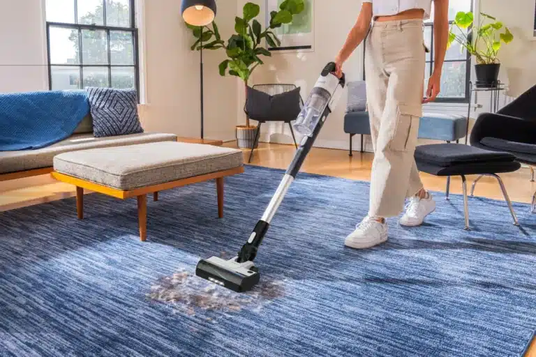 Aspirateur balai sans fil Levoit LVAC 300 posé dans un salon avec sol dur utilisé au quotidien pour un nettoyage rapide et efficace dans un intérieur réel avec miettes poussière et poils d’animaux