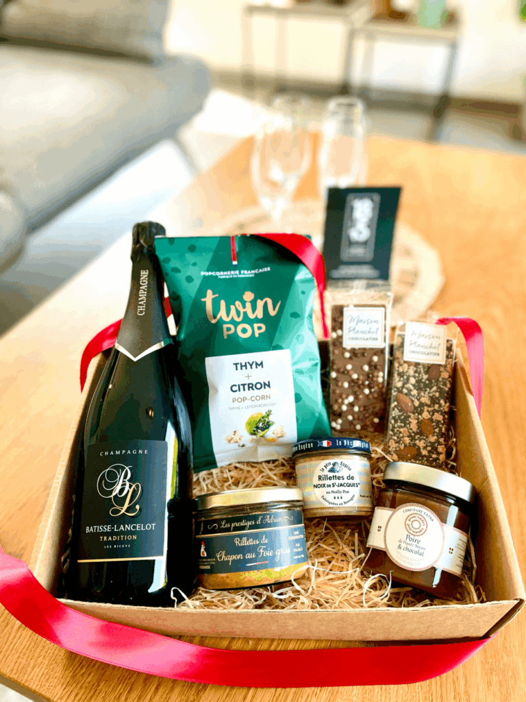 Champagne, gourmandises salées et tablettes de chocolat pour illustrer le coffret Prestige proposé par 18h15.