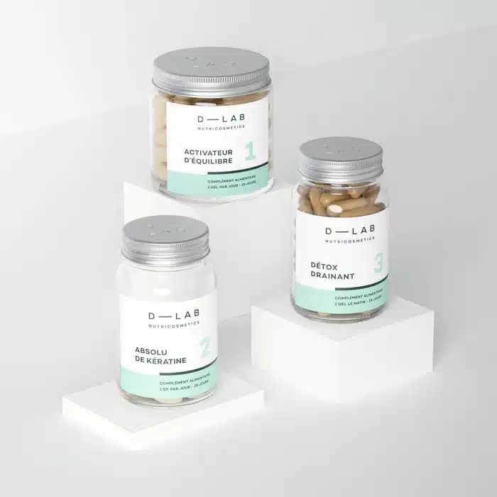 présentation de la Routine Après Bébé de D Lab avec ses trois compléments alignés sur une surface claire, ambiance sérénité et récupération, évocation de la chute de cheveux, de la fatigue et du rééquilibrage hormonal
