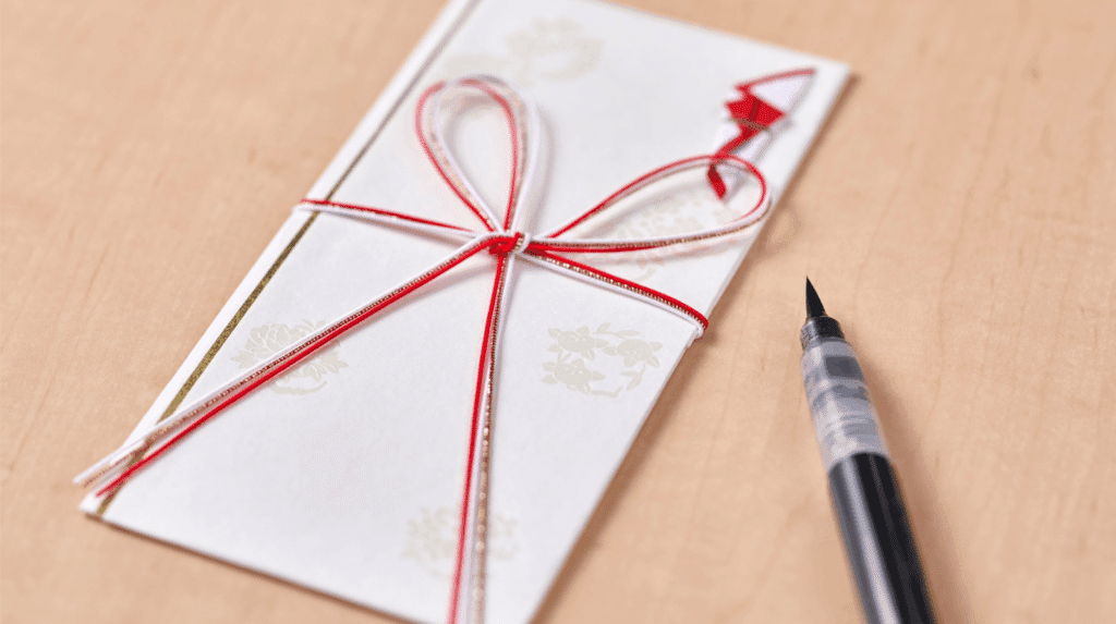 Carte cadeau accompagnée d’un mot manuscrit sur une carte, montrant comment ajouter de l’émotion et de l’intention pour rendre un cadeau plus personnel.