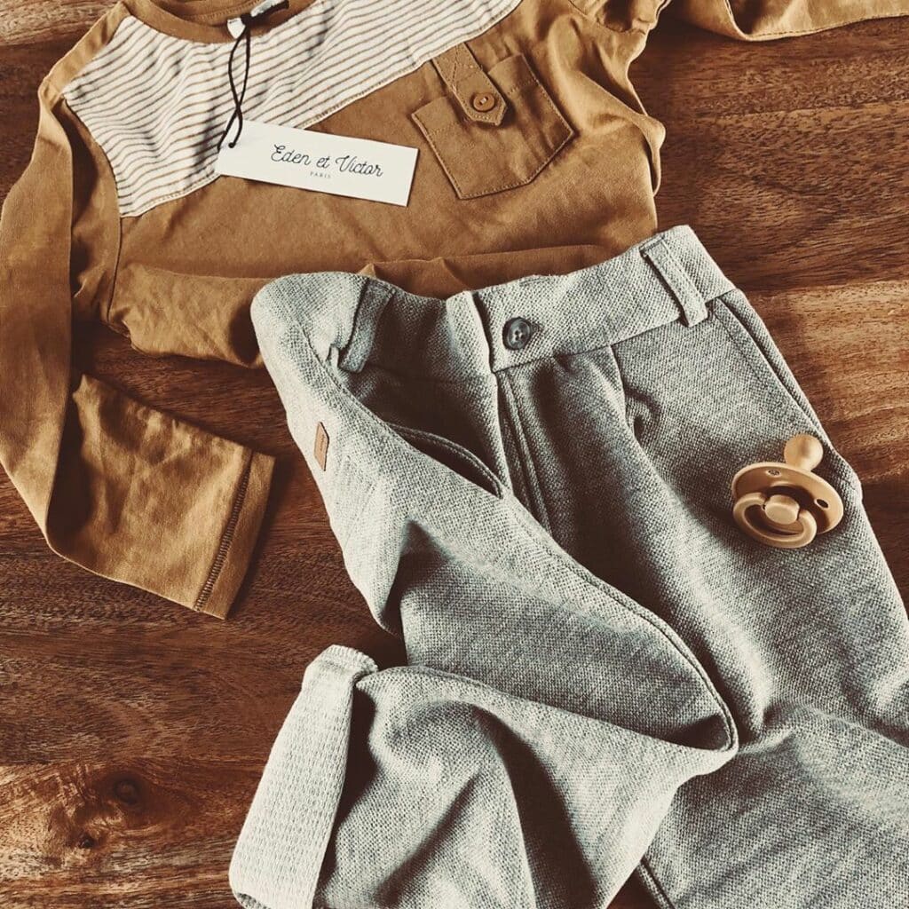 Photo d’une Malle Little Cigogne ouverte avec plusieurs vêtements assortis prêts à être essayés afin de montrer le contenu typique les matières les looks et les prix entre 10 euros et 30 euros.