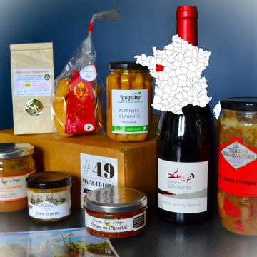 Planche de produits salés et bouteille de vin pour illustrer le contenu typique d’une box La Gourmet Box.
