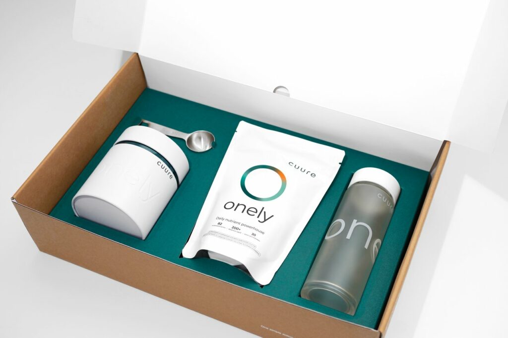 Onely Cuure complément alimentaire tout en un en poudre présenté dans son kit avec gourde et cuillère doseuse