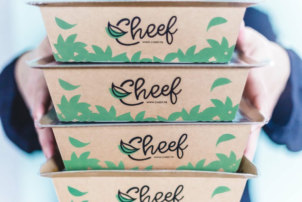 Femme utilisant un ordinateur portable pour commander un programme Cheef en ligne, avec champ code promo visible dans le panier et remise de 10 pourcent appliquée