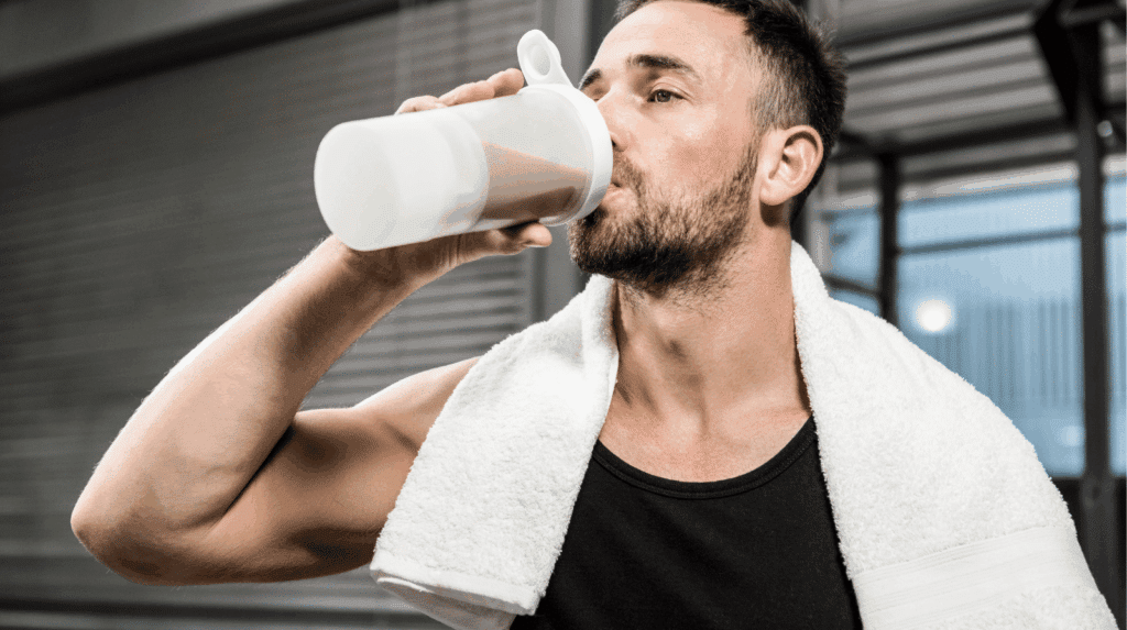 Main tenant un pot de whey protéine en train de lire l’étiquette nutritionnelle