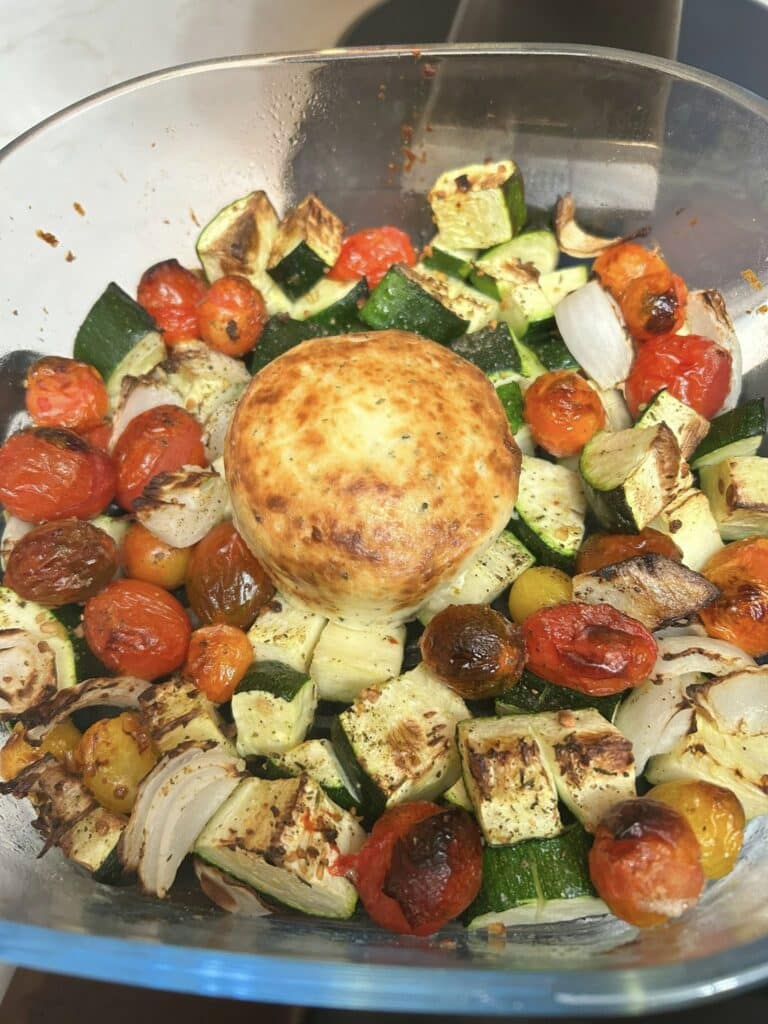 Courgettes, tomates et oignons rôtis dans le Ninja Crispi avec un fromage Boursin fondant placé au centre du plat en verre